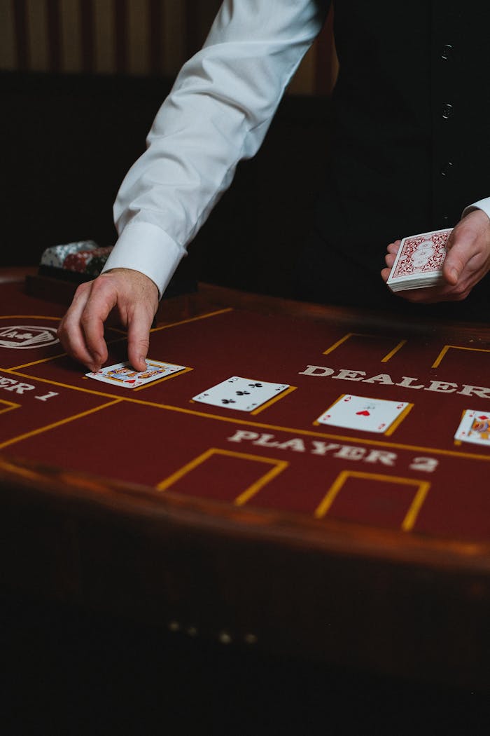 Dealer handling cards at a casino table during a game.